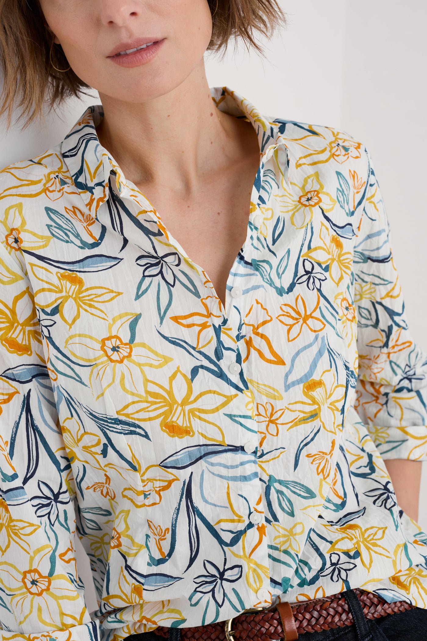 Close-up of the shirt's fabric texture, emphasising the soft organic cotton material and the intricate floral pattern.