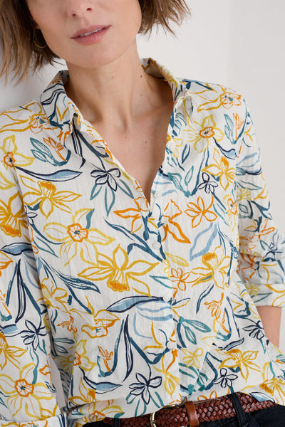 Close-up of the shirt's fabric texture, emphasising the soft organic cotton material and the intricate floral pattern.