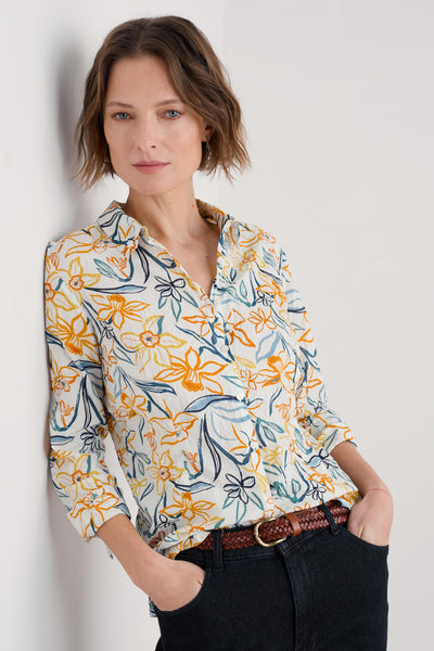 Model wearing the Seasalt Larissa Shirt in Painted Daffodil Chalk, featuring a semi-fitted silhouette, collared neckline, and long sleeves with button loops for adjustable cuff styling.