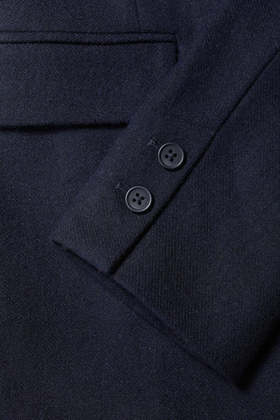 Close-up of a dark blue garment with buttons on a matching fabric background
