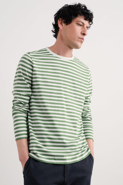 A model wearing the Seasalt Men's Sailor Shirt in Mini Cornish Willow Chalk, showcasing the green and white horizontal stripes, crew neckline, and long sleeves.