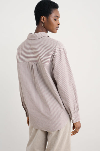 Person wearing a striped organic cotton shirt and pants on a white background