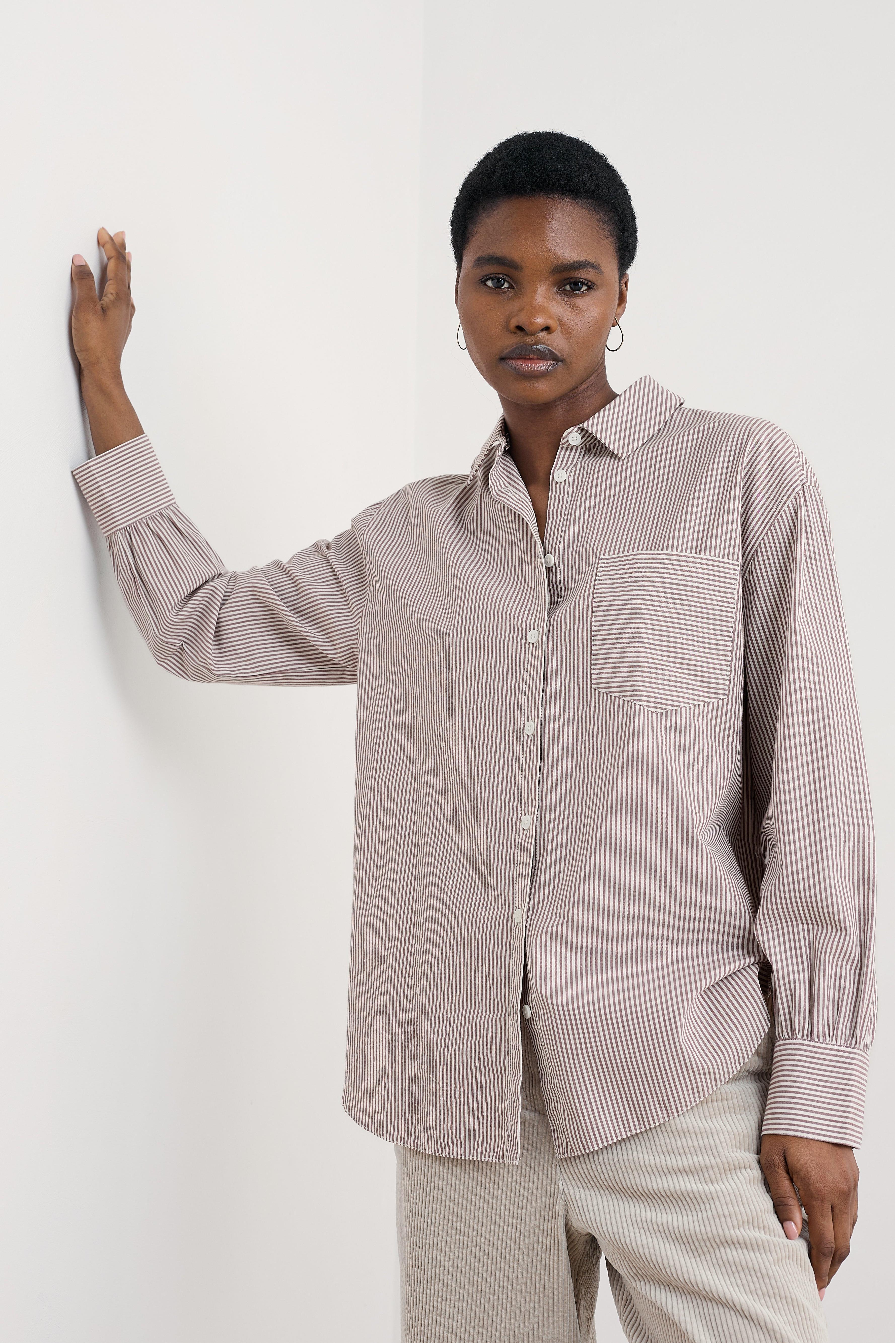 Woman wearing a striped organic cotton shirt and pants against a white background