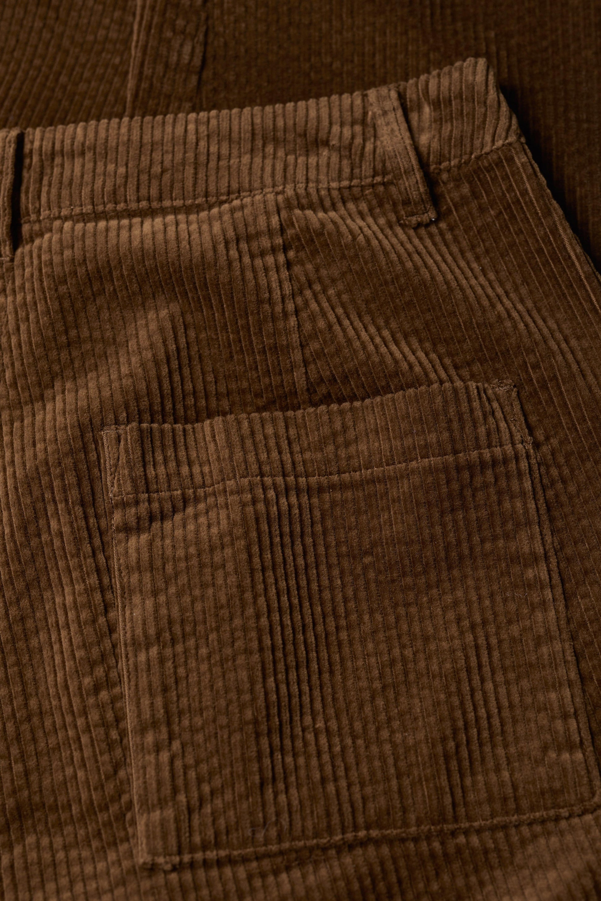 Close-up of brown corduroy pants with a pocket