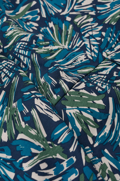 Close-up of organic cotton fabric with blue, green, and white leaf pattern