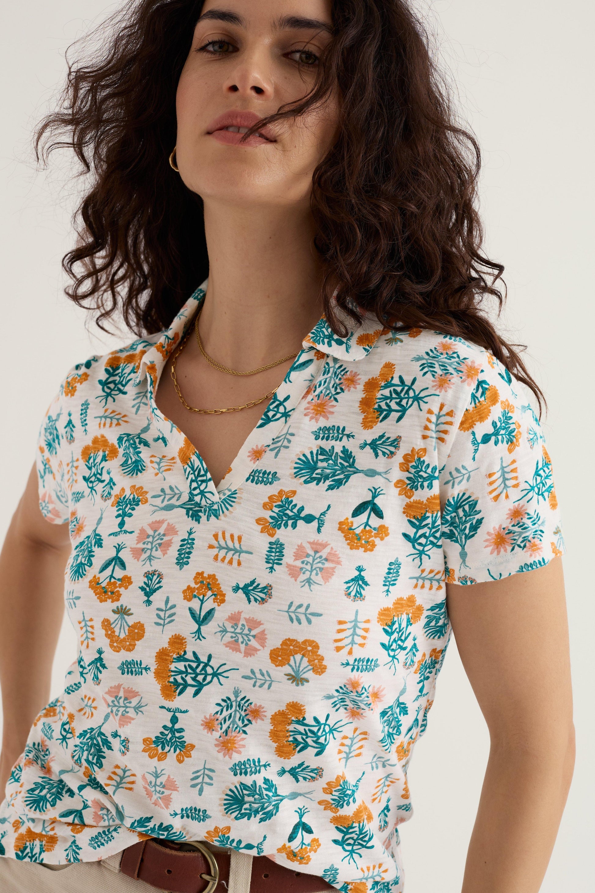 Woman wearing a floral patterned shirt against a plain background