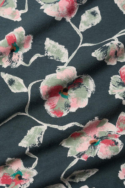 Floral patterned fabric with pink and green flowers on a dark background