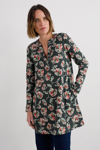 Woman wearing a floral long-sleeve tunic against a white background