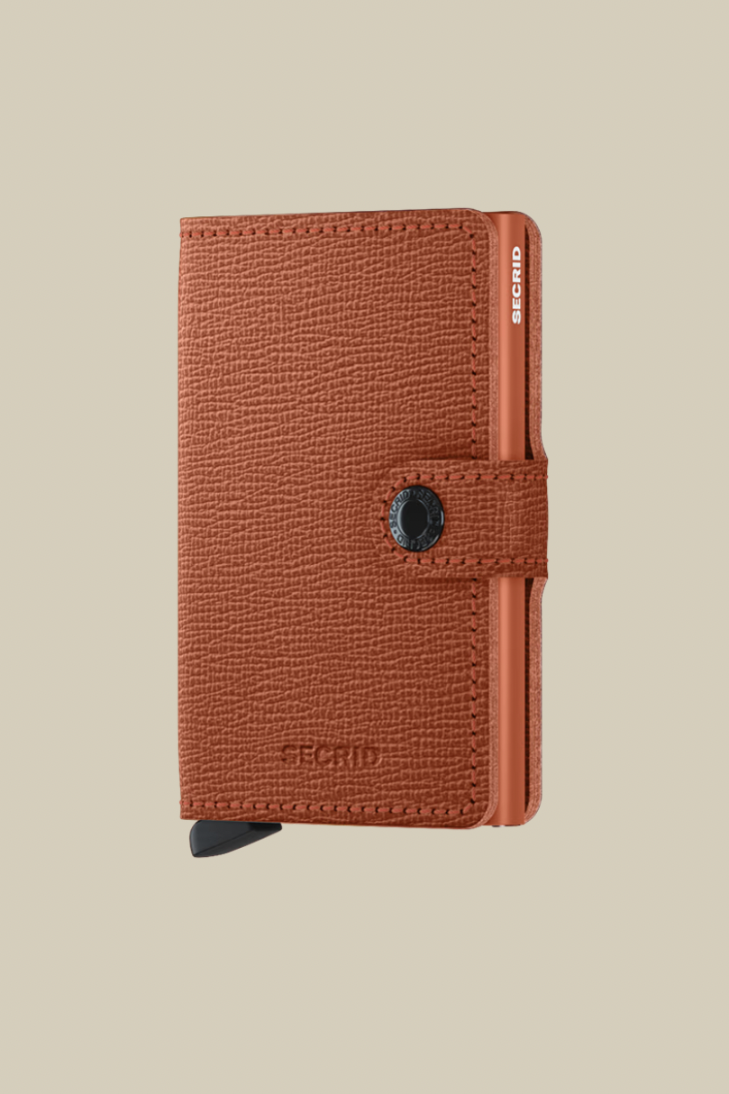 Orange wallet with brand logo on a beige background