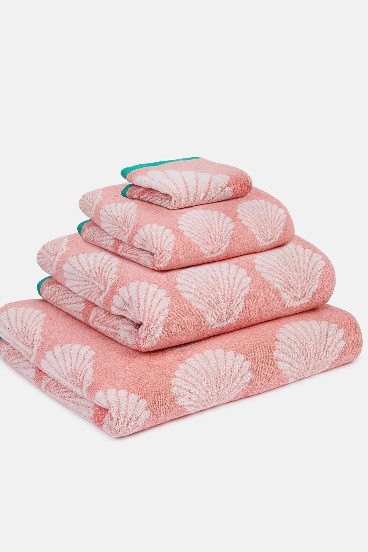 Set of pink organic cotton towels with shell pattern on a white background