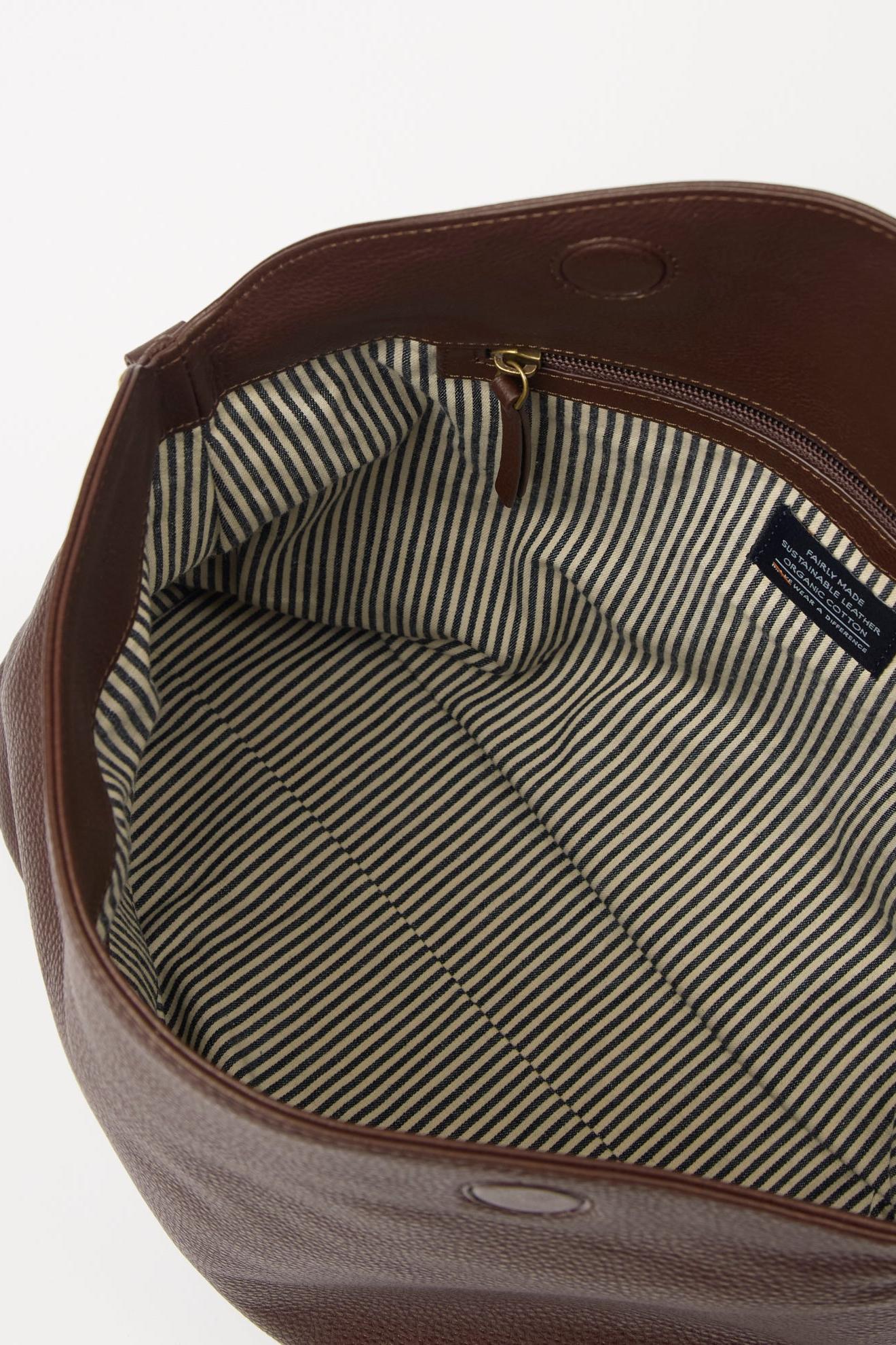 Brown leather bag with striped lining on a white background