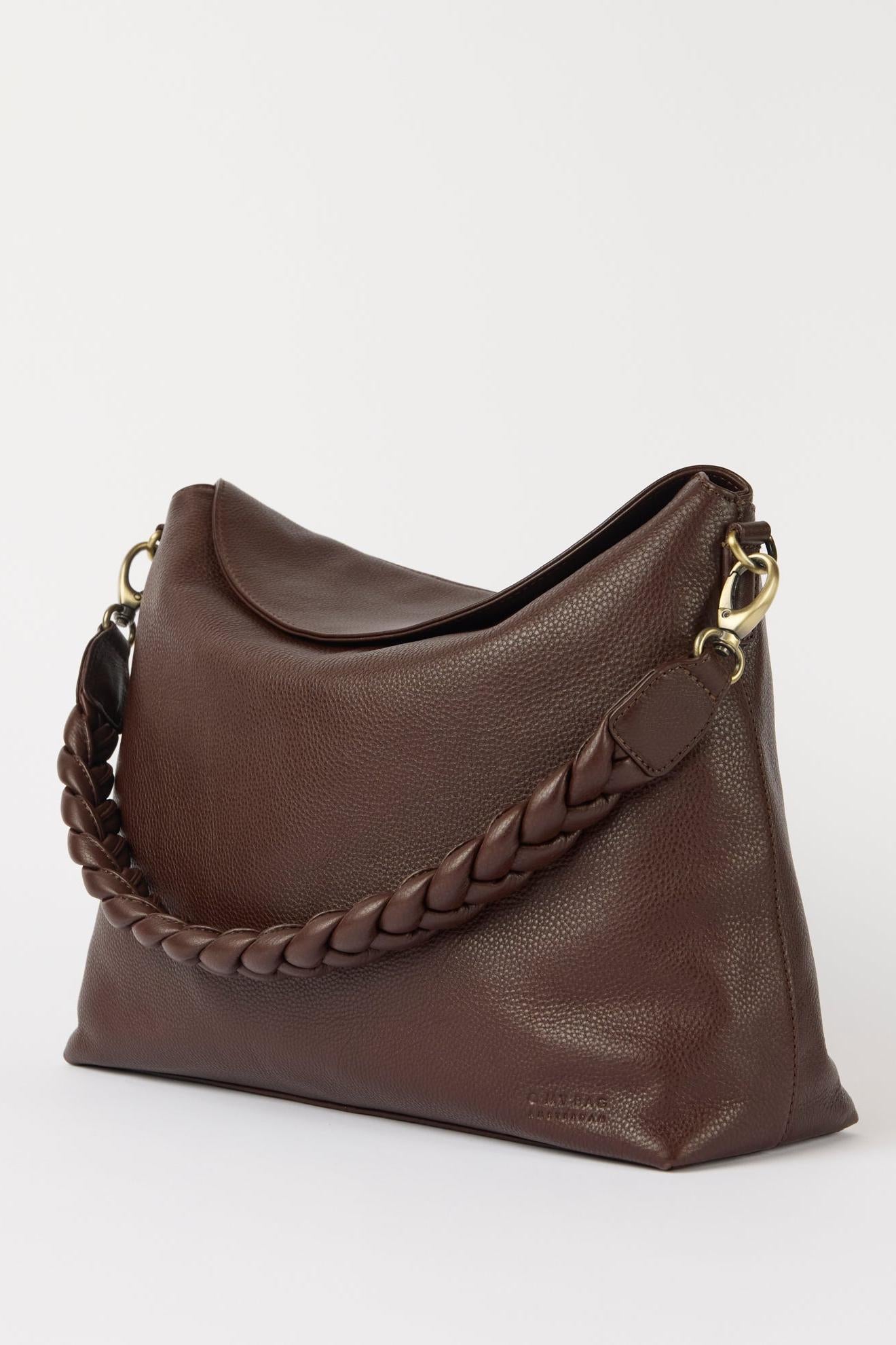 Brown leather handbag with braided handle on a white background