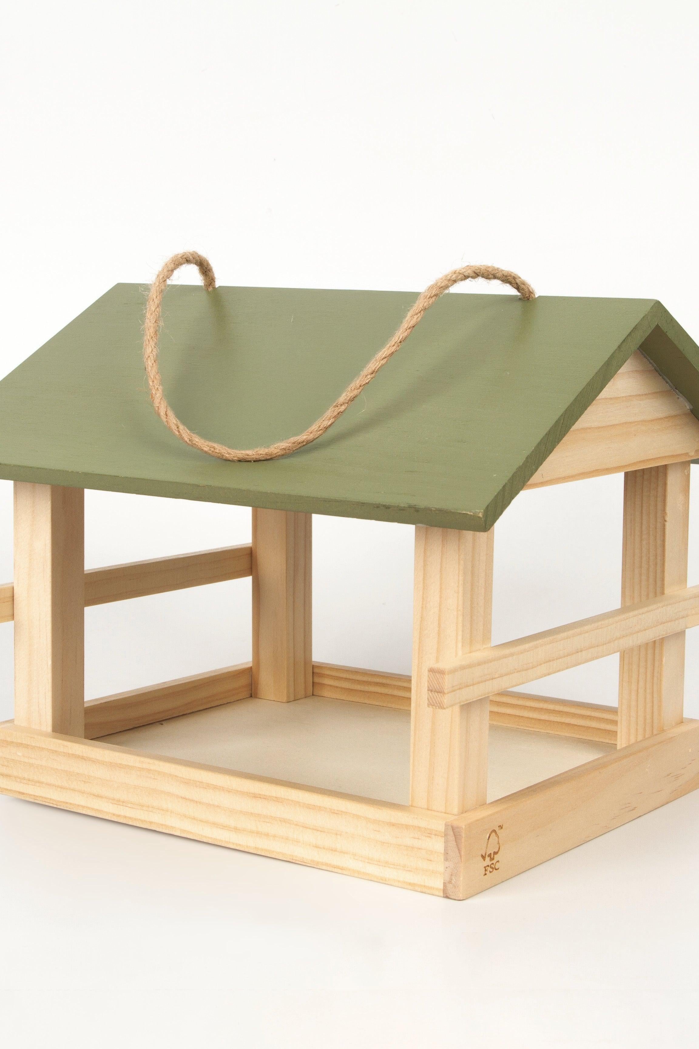Wooden birdhouse with a green roof and rope handle on a white background