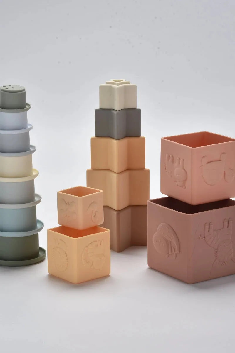 Set of colorful square building blocks with embossed designs on a light gray background