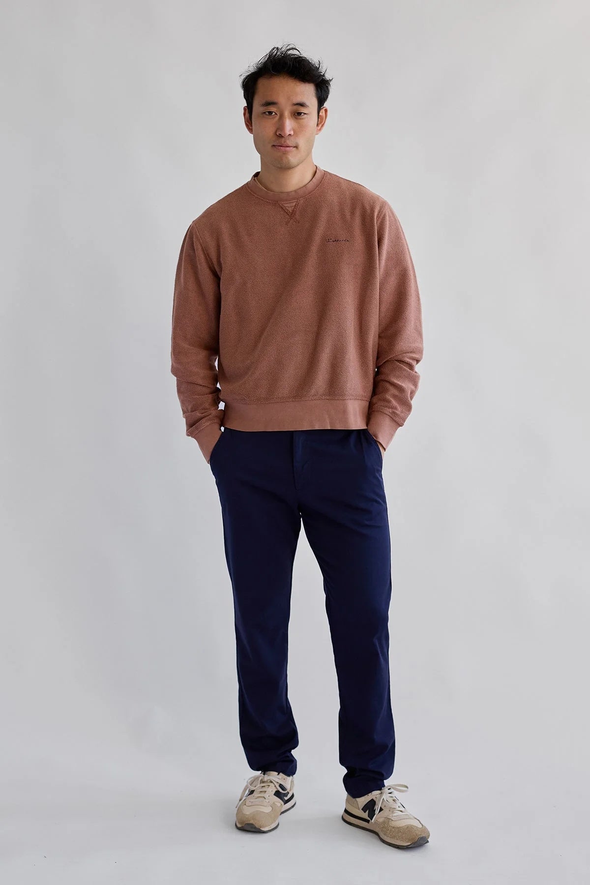 Model wearing the TWOTHIRDS Fatu Hiva Sweatshirt in Coconut Shell, paired with casual pants and new balance trainers.