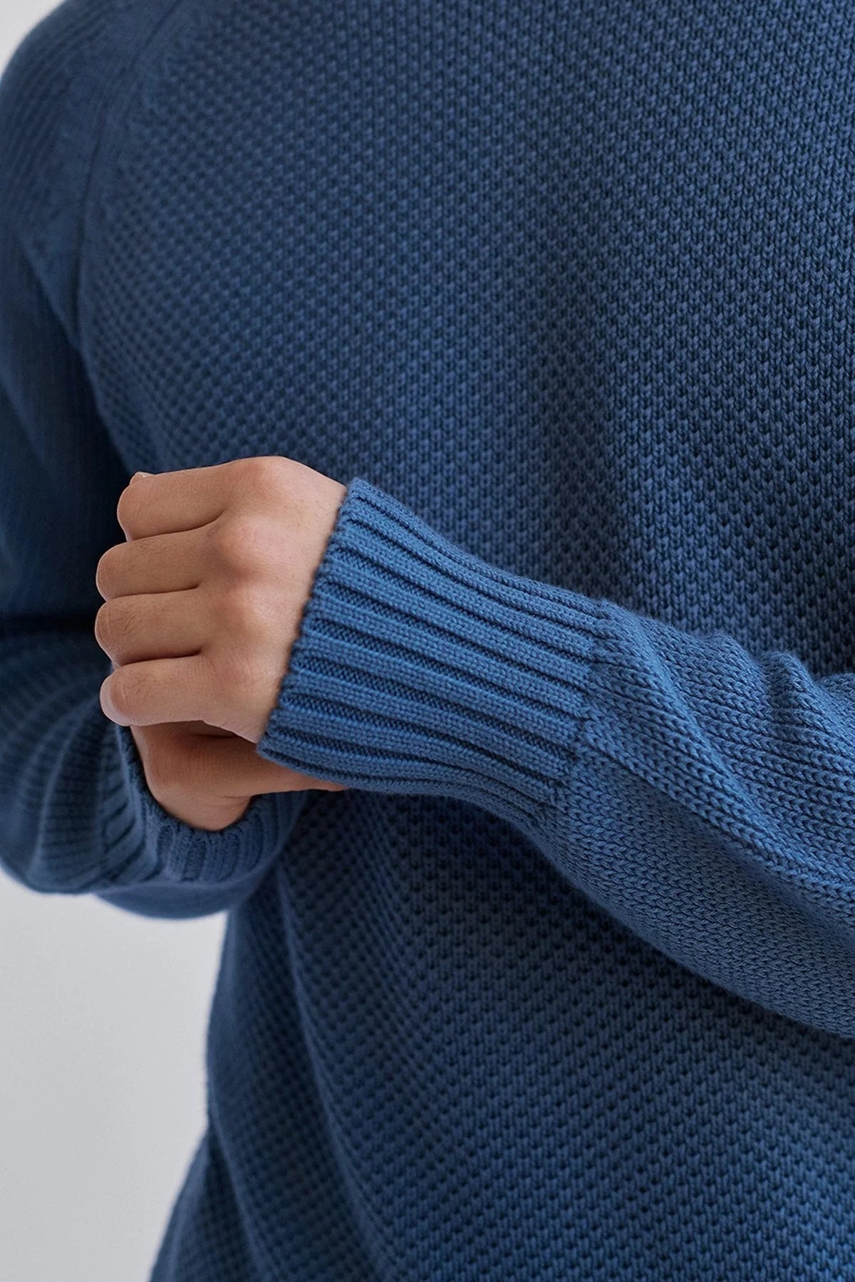Close up of ribbed cuffs on organic cotton blue jumper.
