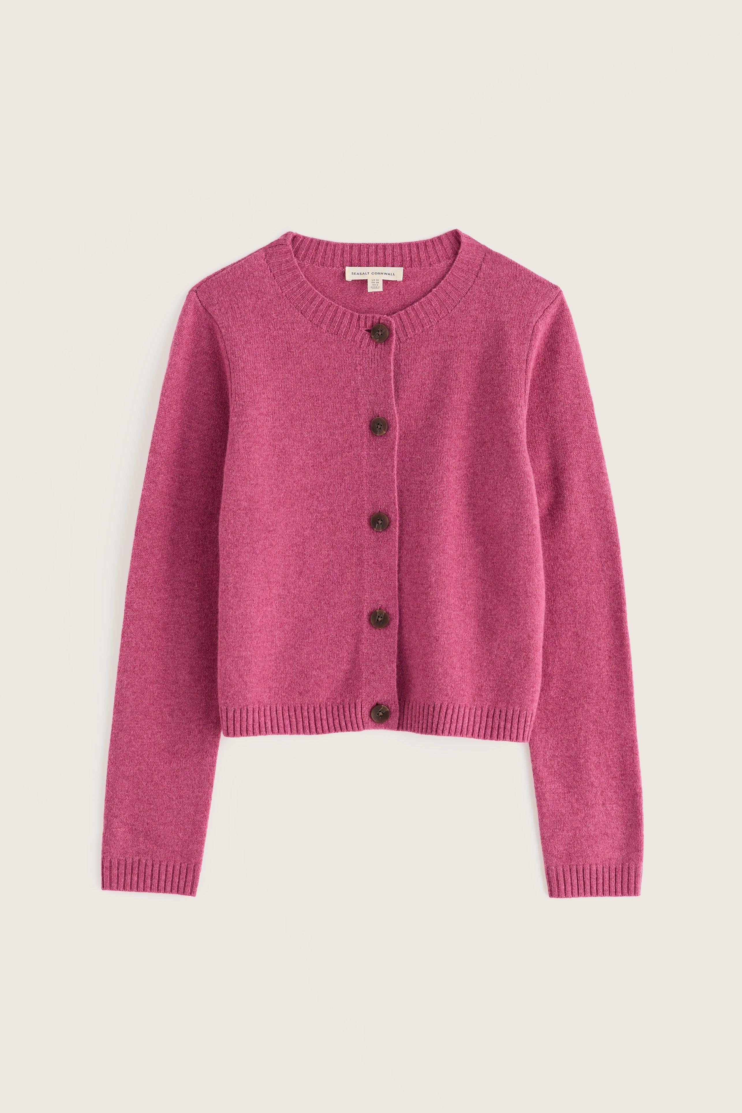 A pink knit cardigan sweater with dark buttons, displayed flat against a light beige background.