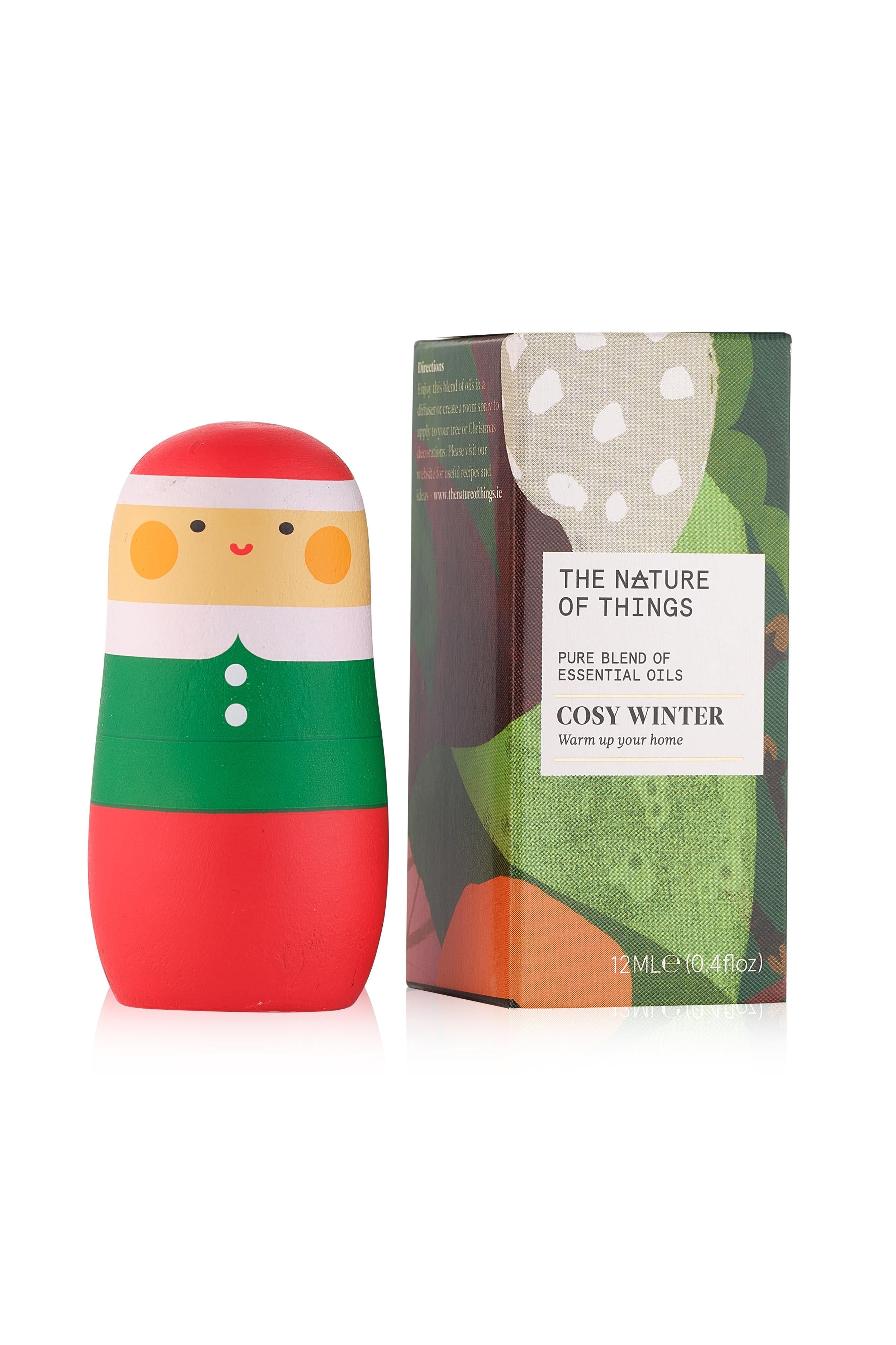 Decorative bottle with elf design and packaging labeled 'Cosy Winter' on a white background