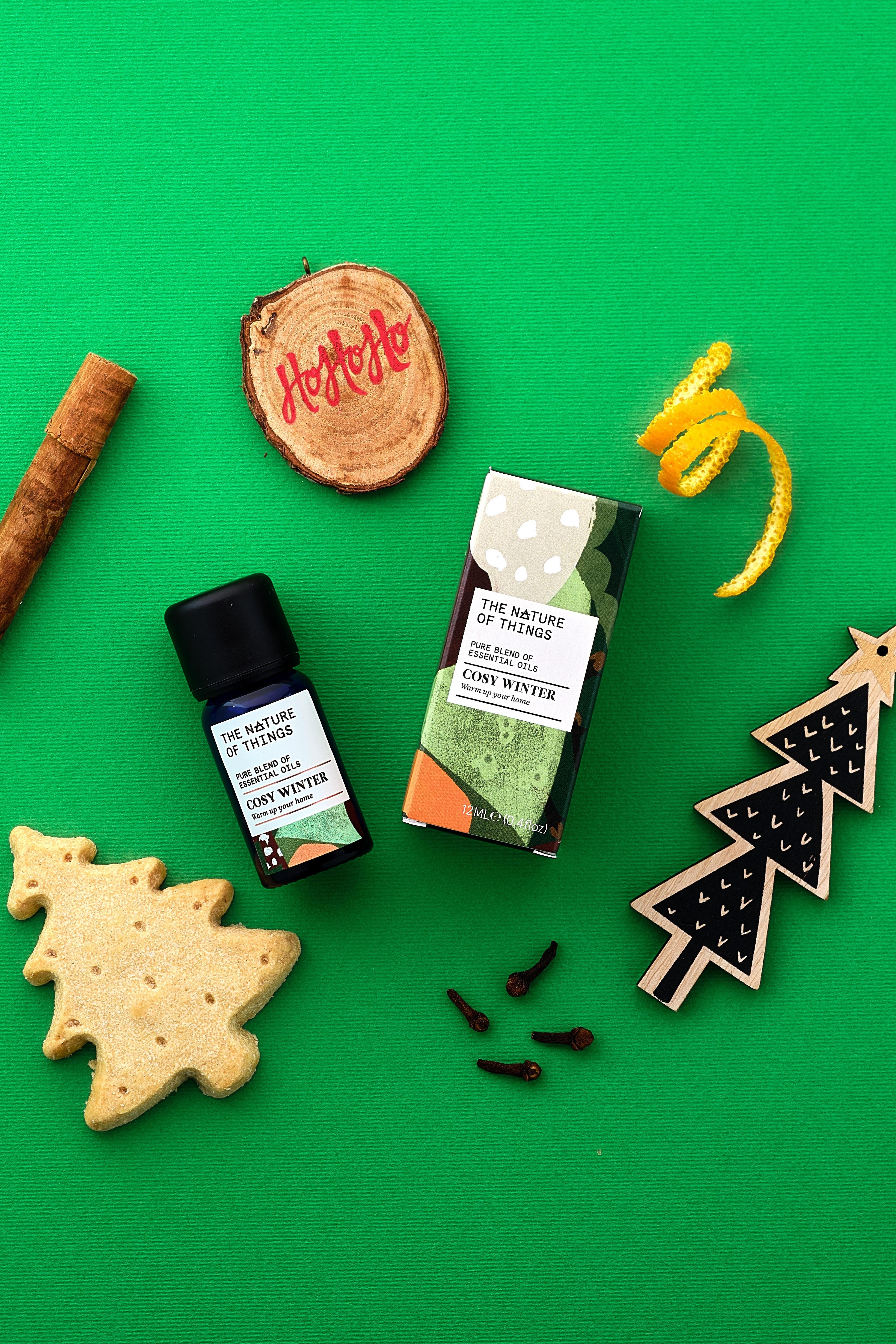 Collection of Christmas-themed items including a bottle, christmas tree, and cookies on a green background