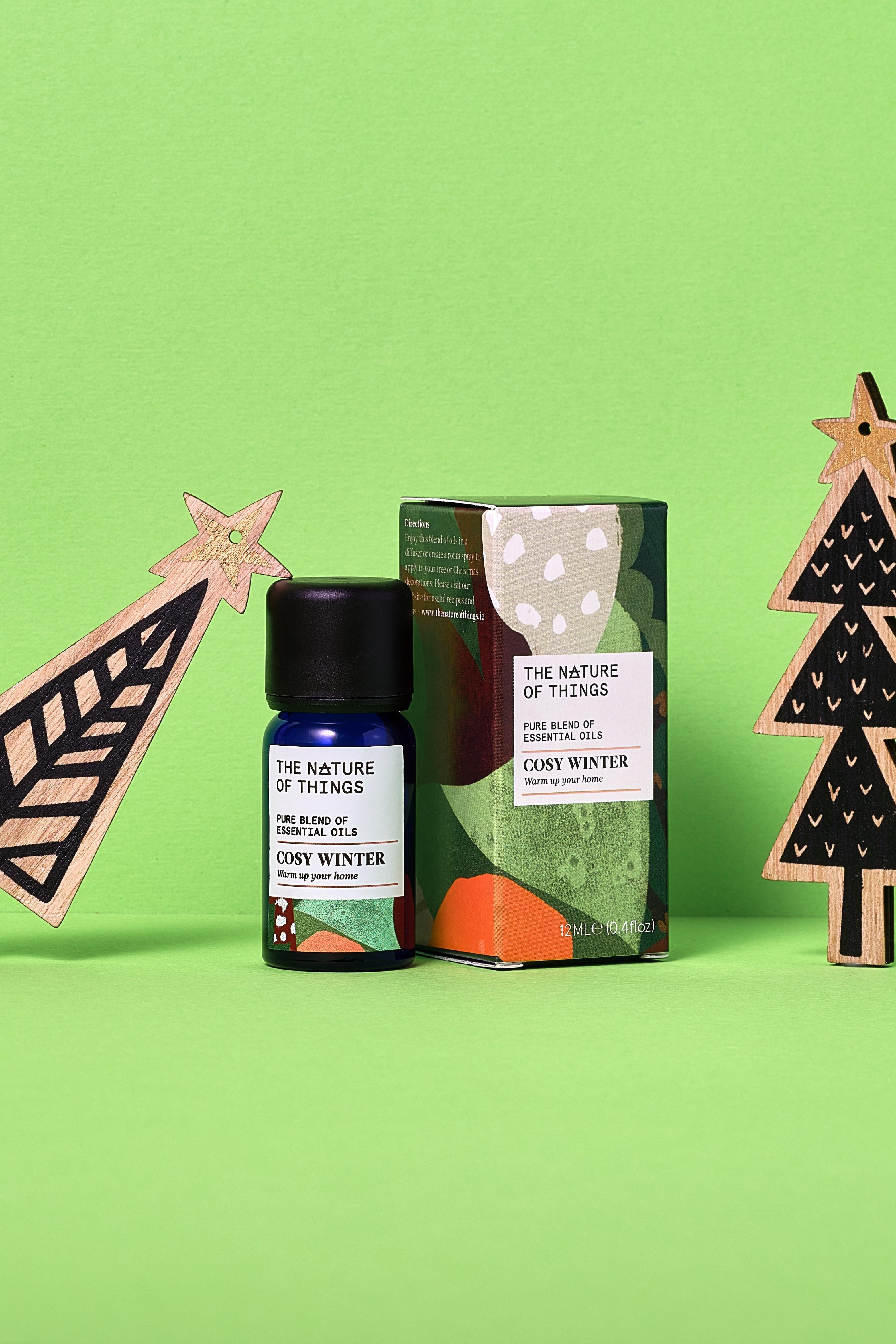 Cosy Winter product packaging with decorative trees on a green background