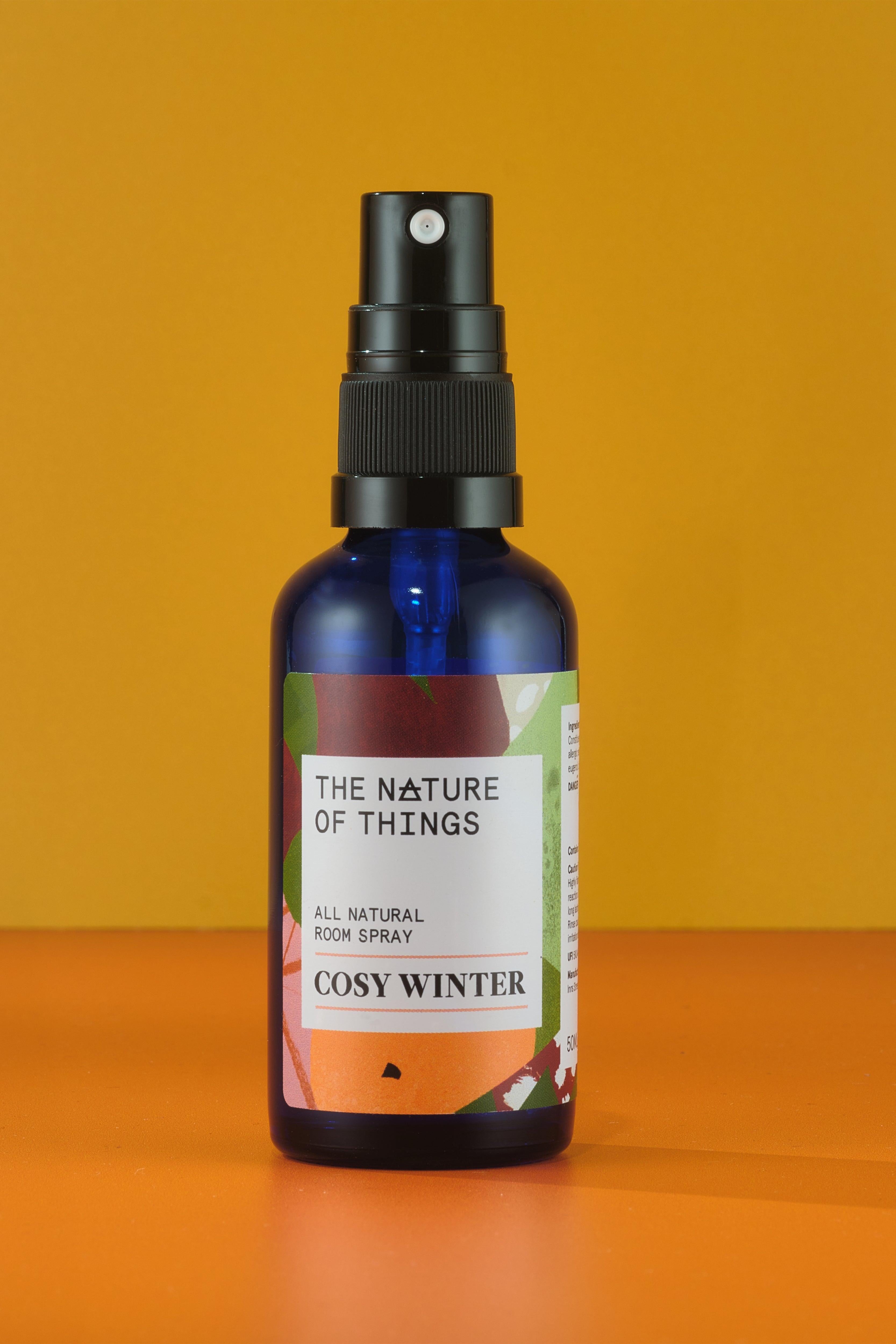 Bottle of 'Cosy Winter' room spray by 'The Nature of Things' on an orange background