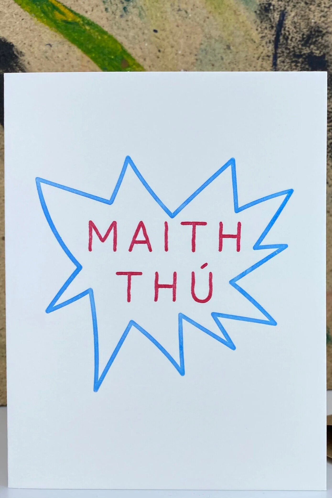 Card with 'MAITH THÚ' text in a blue star shape on a white background