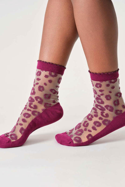 Sheer bamboo socks with pink leopard print and purple accents worn by a person on a white background