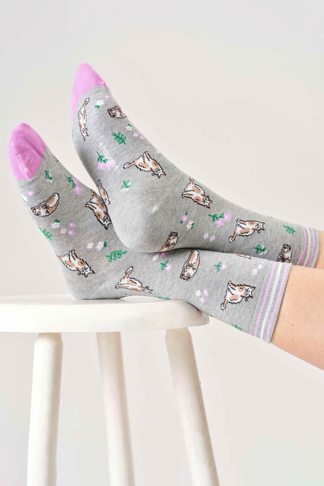 Gray organic cotton socks with cat pattern worn by a person on a white background