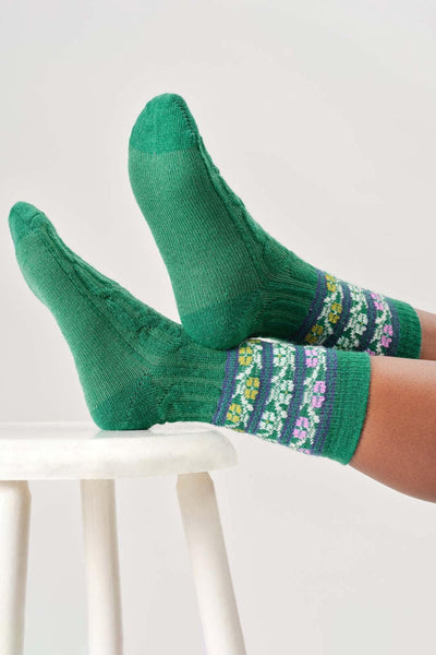 Green wool socks with floral patterns on a white background