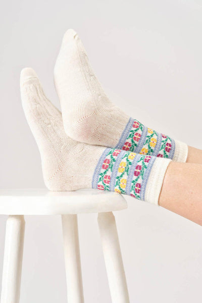 White wool socks with colorful floral pattern on a white background