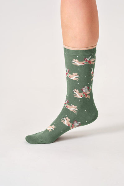 Green bamboo socks with fox christmas pattern worn by a person on a white background