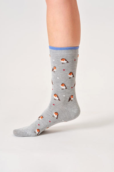 Gray bamboo socks with bird pattern worn by a person on a light gray background