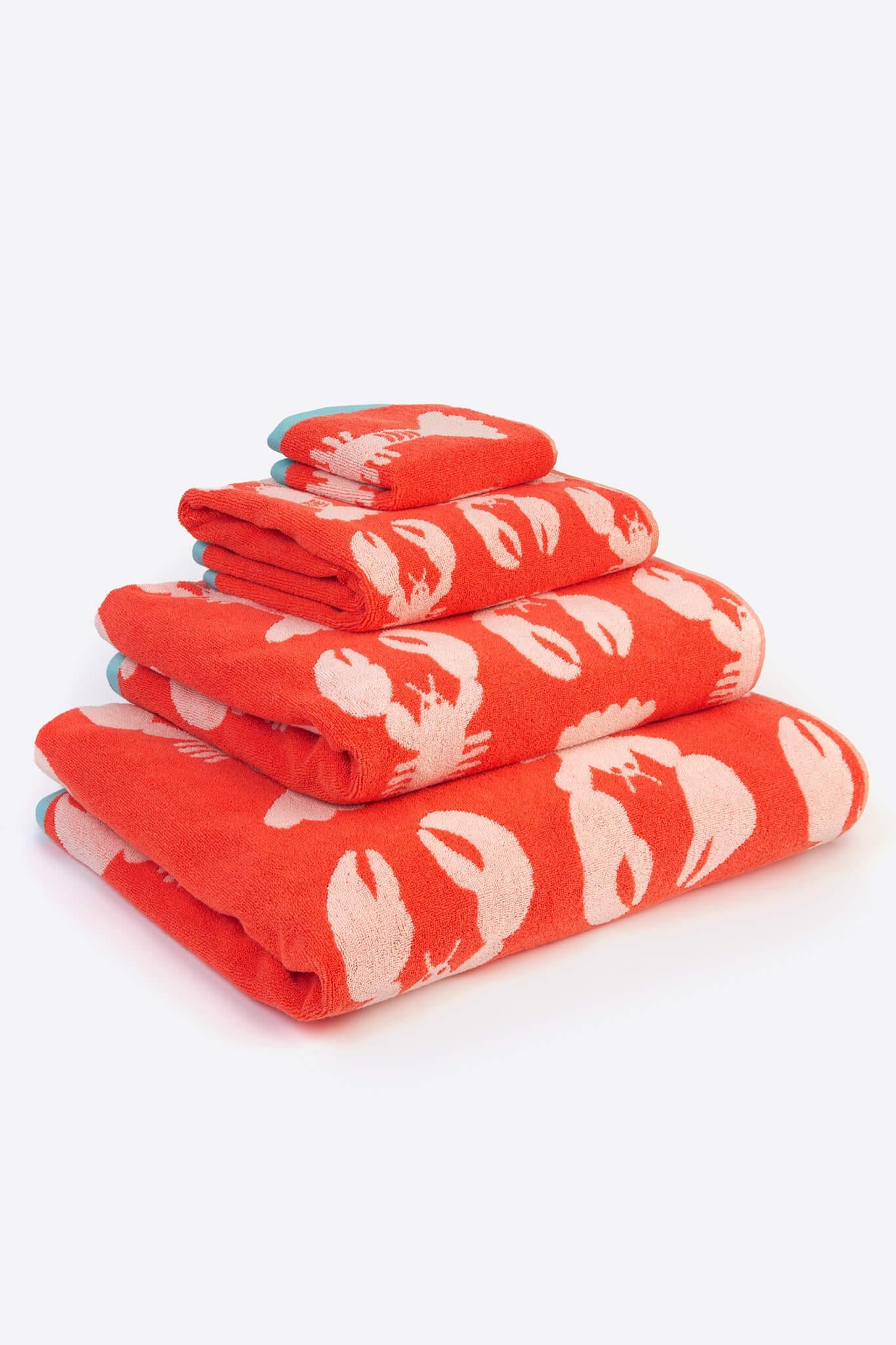 Stack of red towels with white patterns on a white background