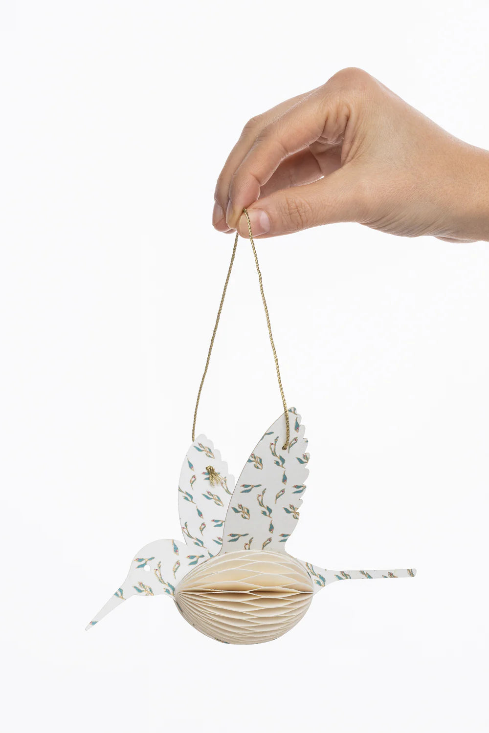 Hand holding a decorative hanging item with floral patterns on a white background