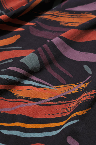 Close-up of organic cotton fabric with abstract colourful pattern on a dark background