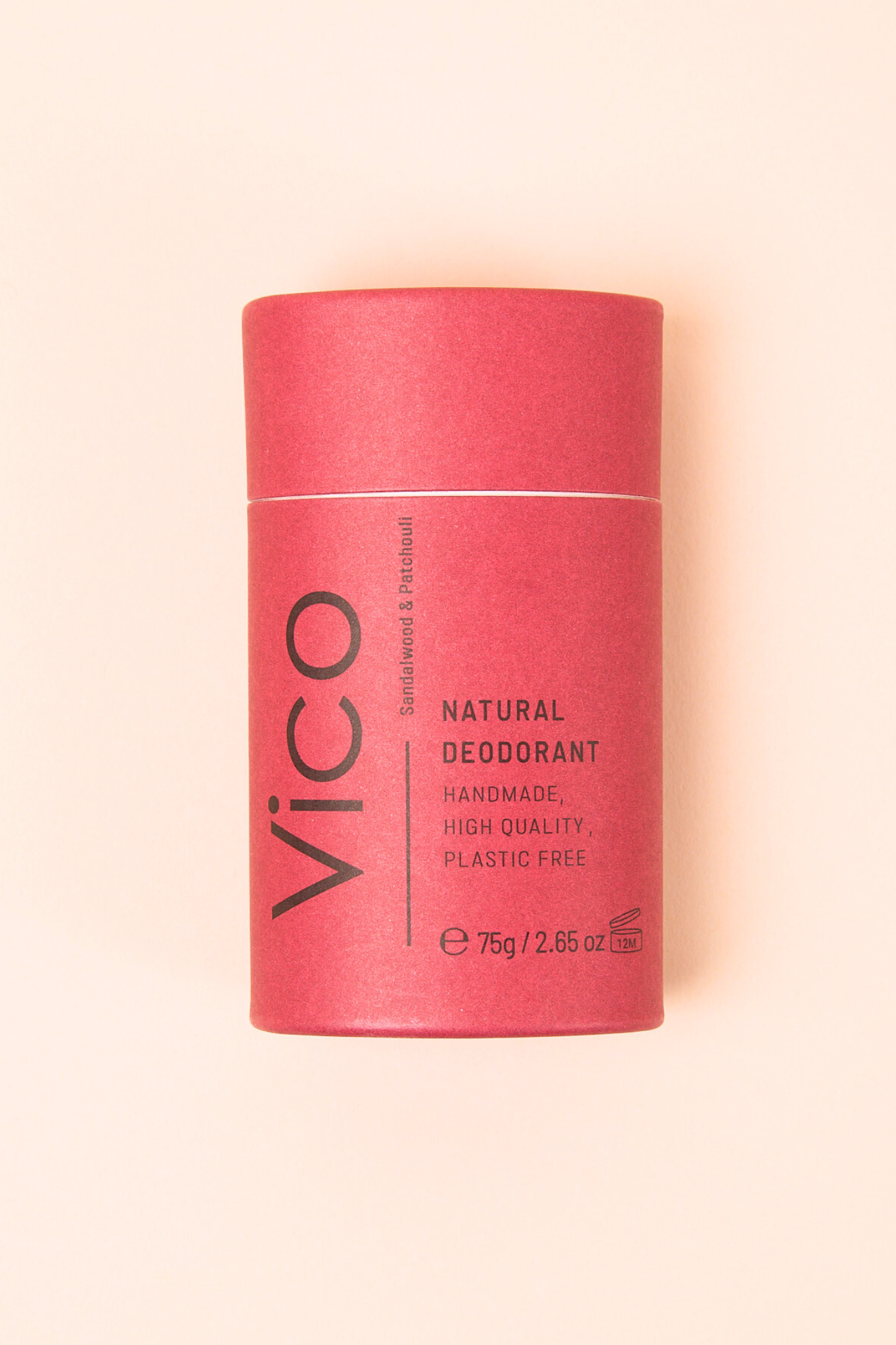 A plastic-free natural deodorant in a deep red cylindrical tube with "Vico" branding, set against a soft beige background.