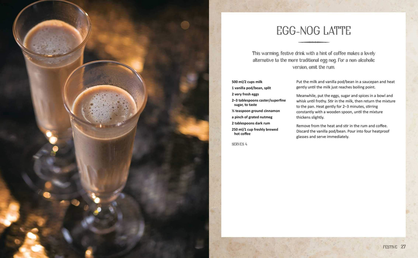 Two glasses of egg nog latte with a recipe card on a textured surface