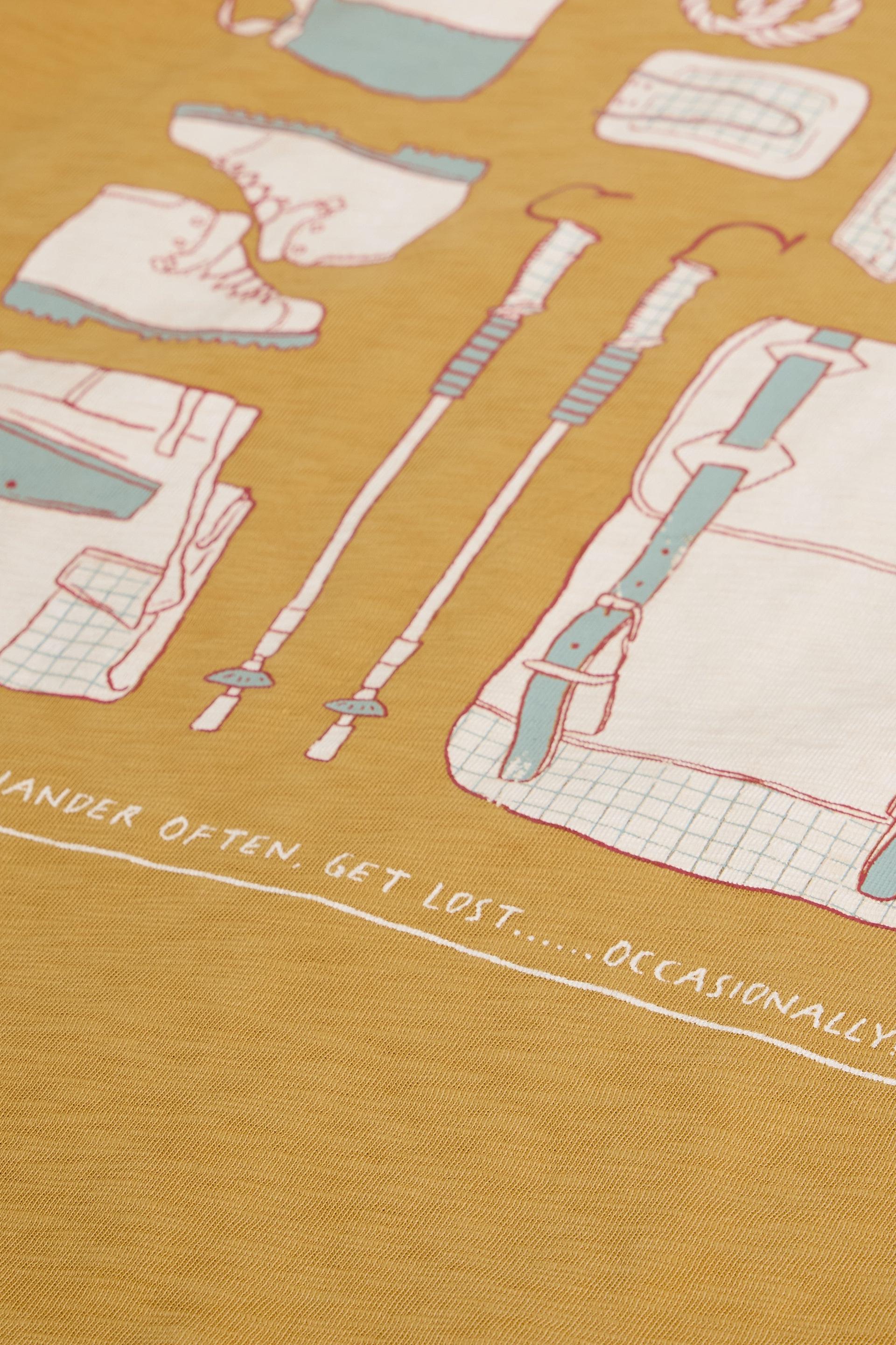 T-shirt with camping-themed design on a mustard background