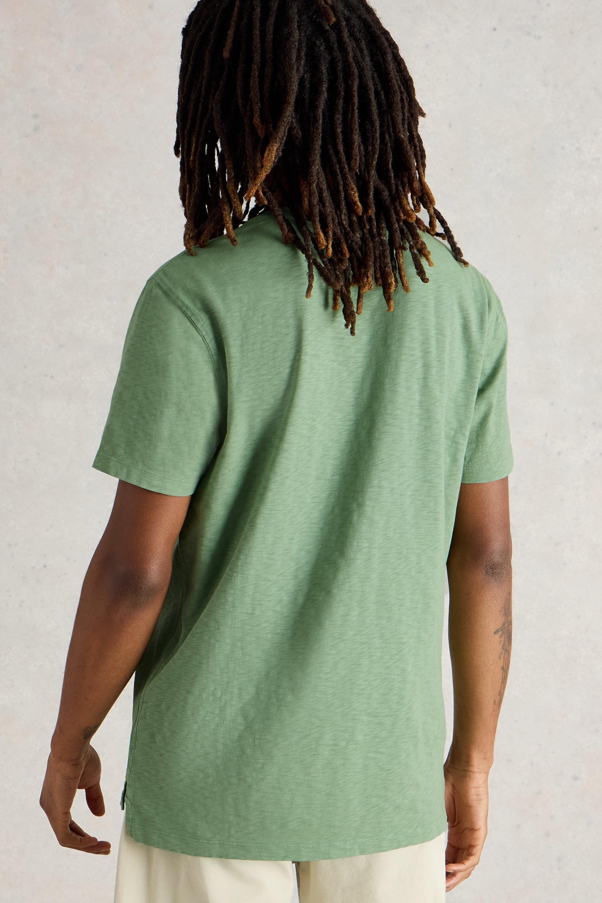 Back view of green cotton t-shirt with short sleeves and medium length.