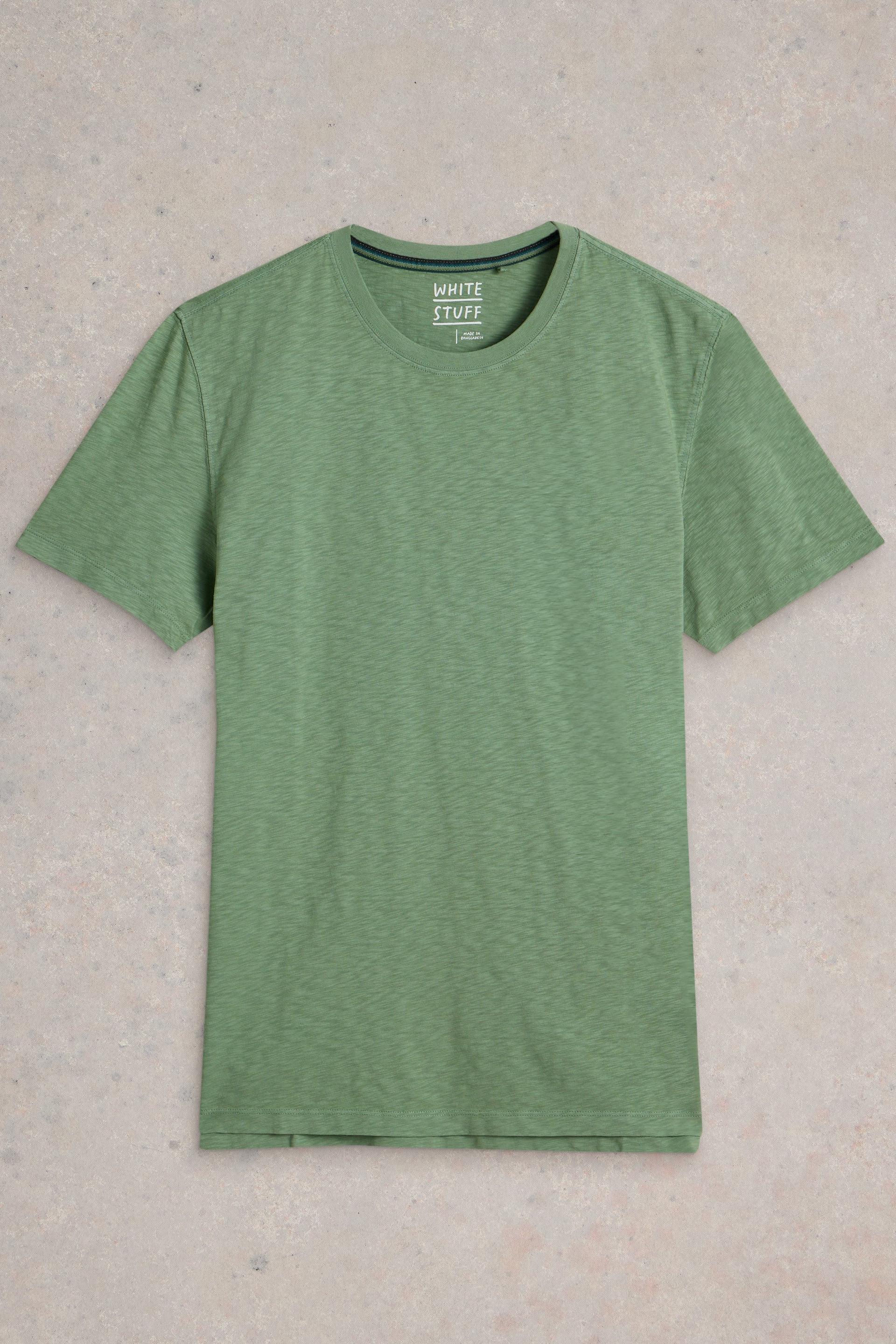 Green cotton t-shirt laid flat on neutral background