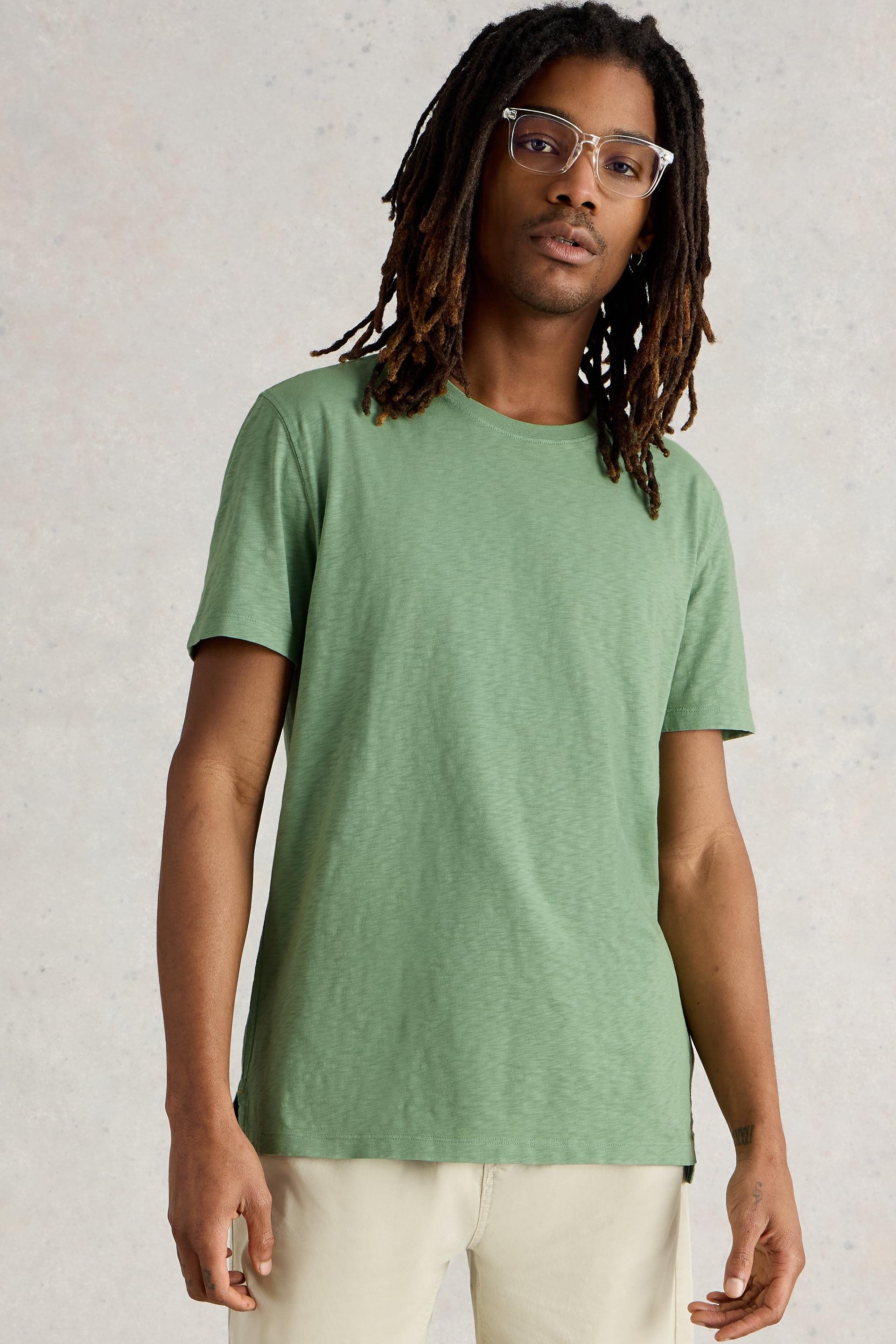 Model wearing green crew neck short sleeved tee.