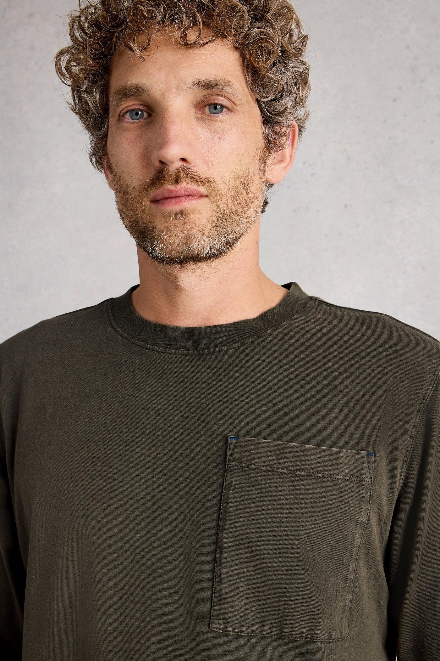 Close up of long sleeve green organic cotton t-shirt with crew neck and large front pocket