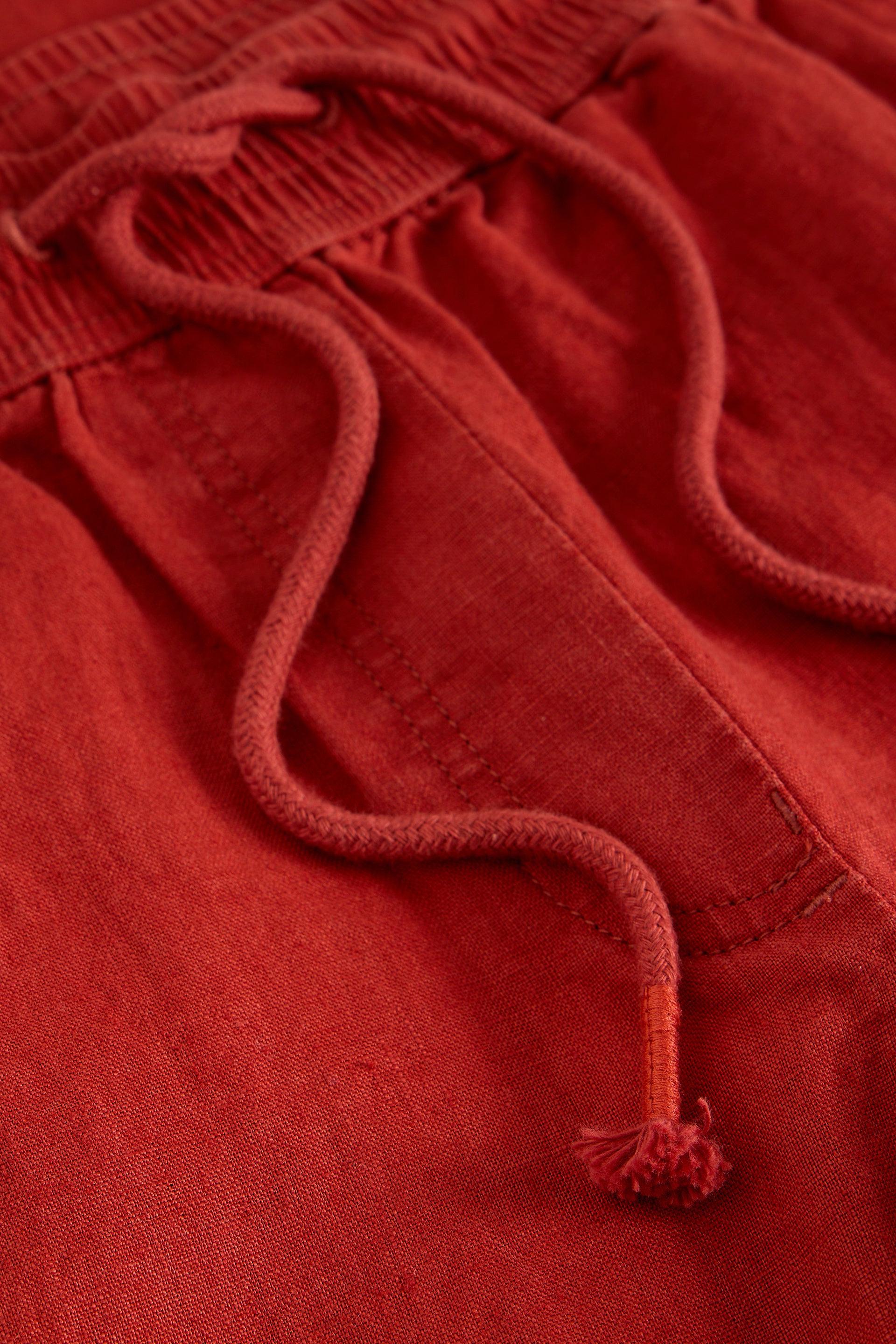 Close-up of red linen fabric with frayed edges