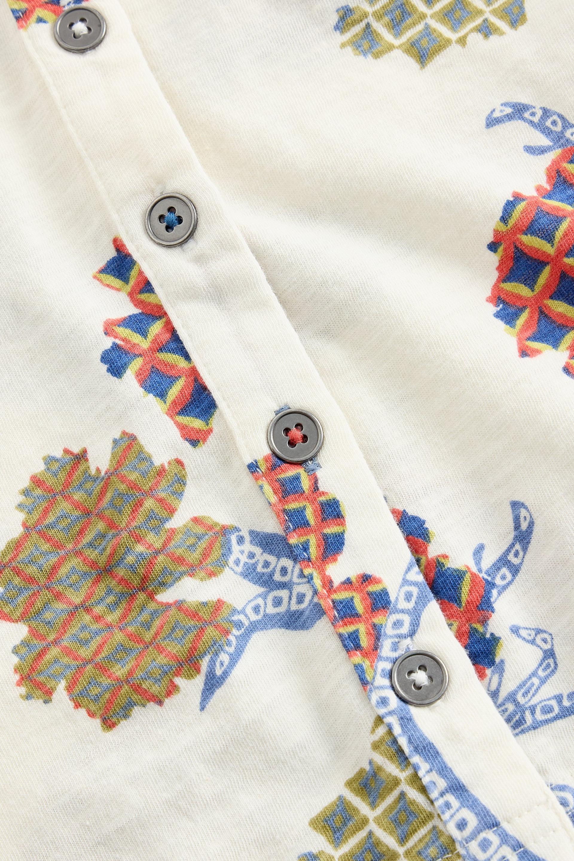 Close-up of a shirt with colorful geometric patterns and buttons.