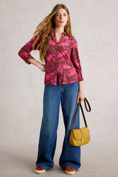Woman wearing cotton jersey shirt, styled with blue denim jeans, yellow handbag and red trainers