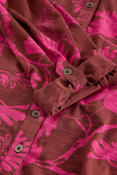 Close-up of button detail on pink floral cotton shirt