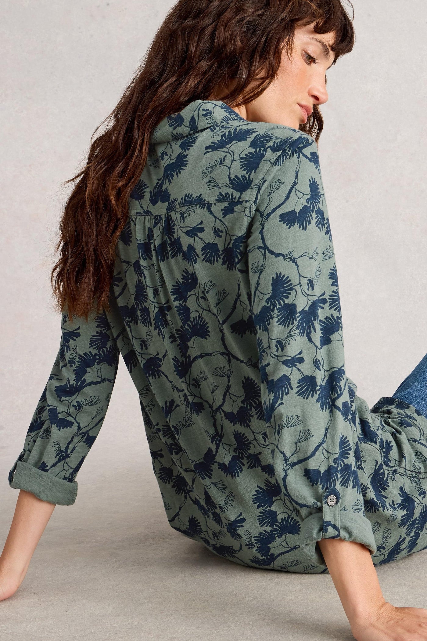 Back of green Annie longline tunic with blue floral print, 100% cotton, showing long sleeves and classic fit, worn by model.