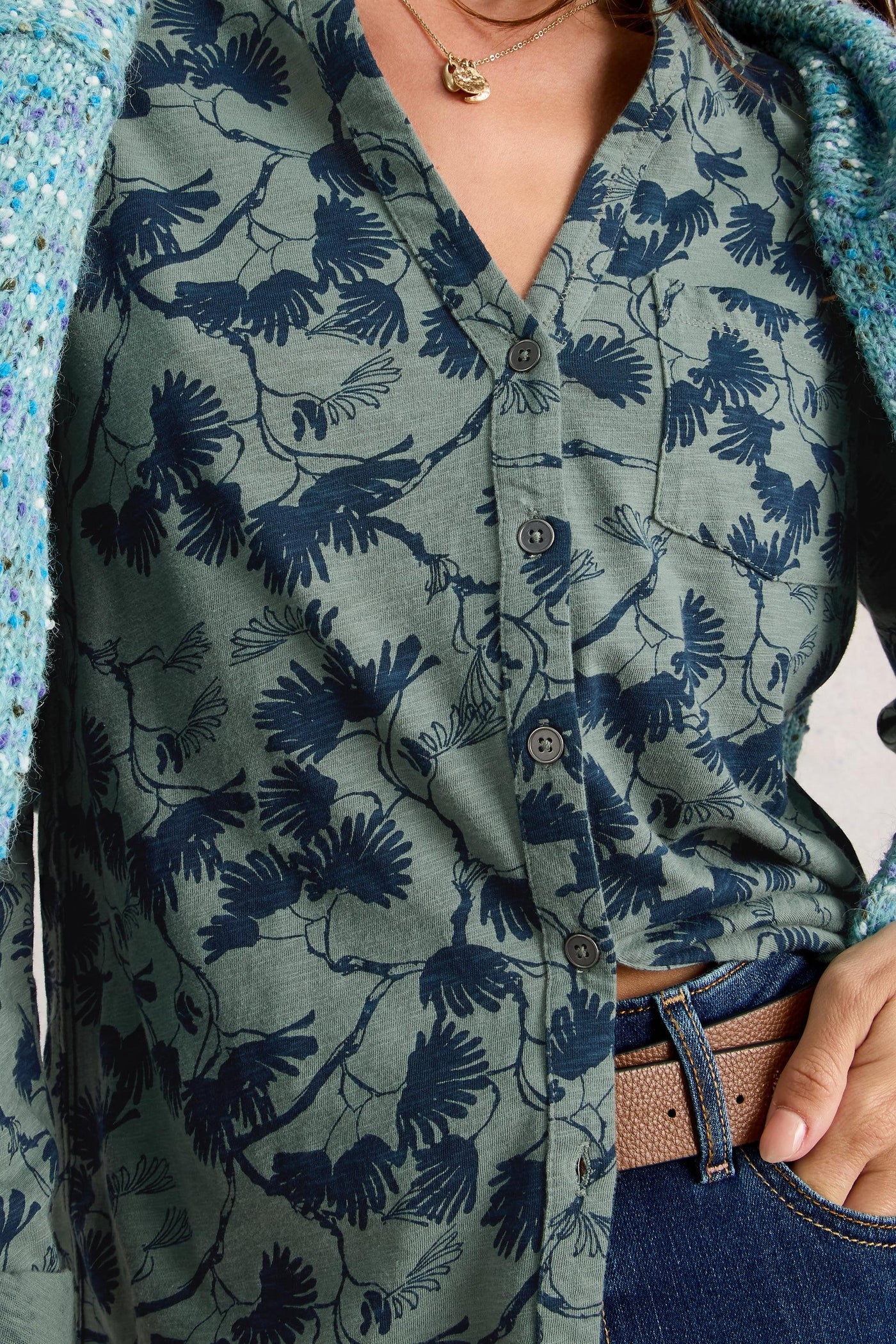 Close-up of green longline cotton tunic, showing pocket detail, buttons and blue floral print