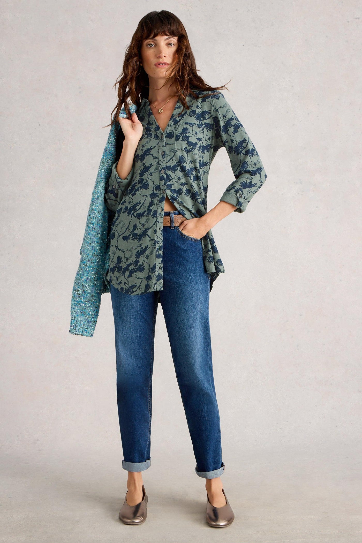 Model wearing blue printed cotton tunic showing long length, styled with blue straight denim jeans and gold pumps