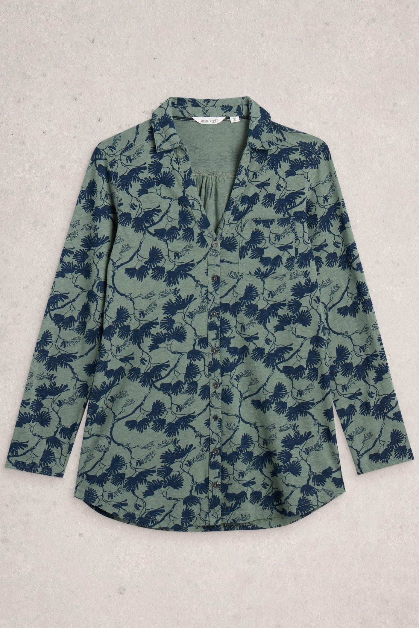 Flat lay of green Annie longline tunic with blue floral print, made from 100% cotton, featuring collar, long sleeves, and pocket